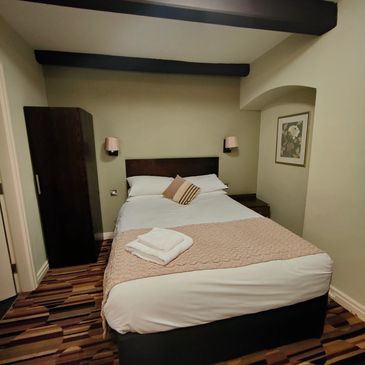 Cozy bedroom with neatly made bed and towels.