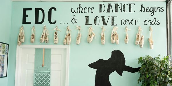 Ballet shoes and dance quote on wall.