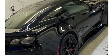 Sleek black sports car with glossy finish and red brake calipers.
