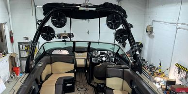 Luxurious Supra boat interior with beige and brown seating inside a garage.