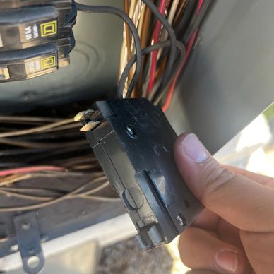 Person Removing a Wire From an Electrical Box