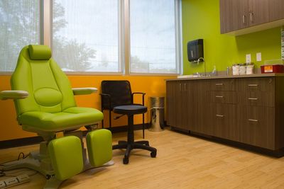 Bright medical examination room with green chair.