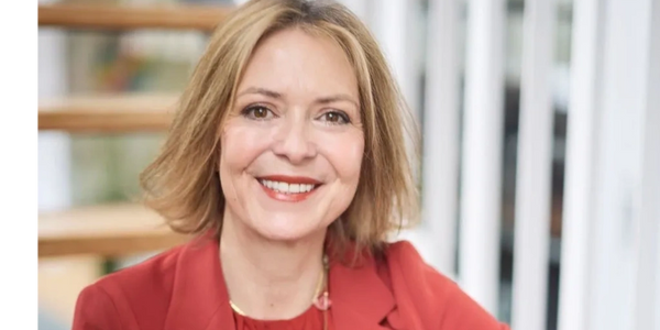 A woman in red jacket smiling for the camera.