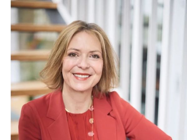 A woman in red jacket smiling for the camera.