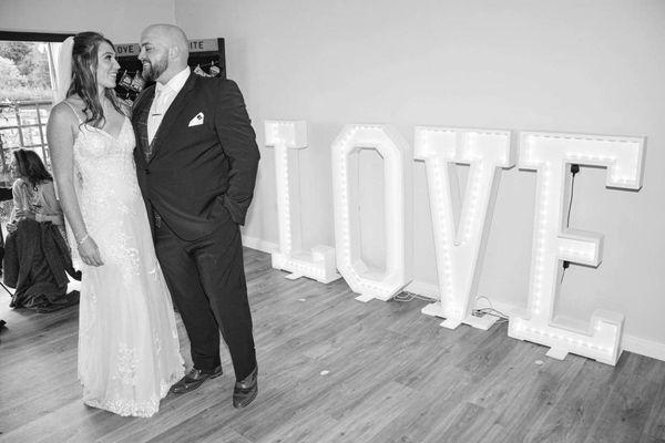 Newly married couple posing in front of the large Light up love letters 