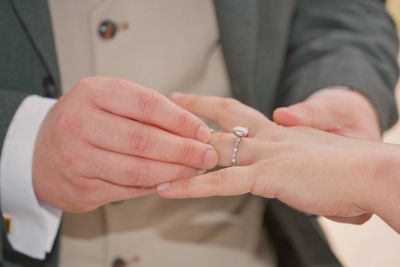 Groom placing the wedding ring on brides finger