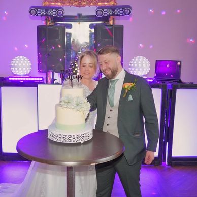 wedding couple cutting their cake in front of the unique DJ setup at Walton Hall Warrington Cheshire