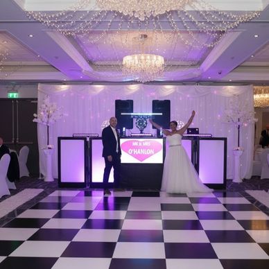 wedding couple stood in front of the unique DJ setup at The Village Hotel Warrington Cheshire
