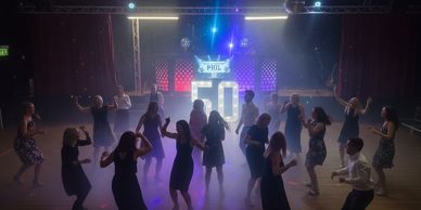 50th birthday with DJ setup and number 50 packed dancefloor
