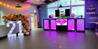 Decorated room for a 21st birthday party with balloons and DJ setup.