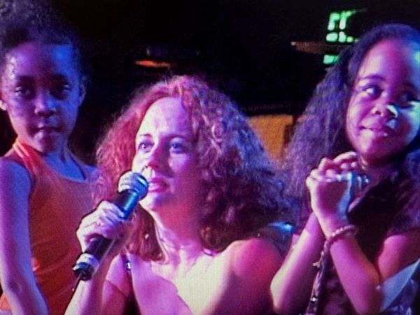 This is a close up of Teena on stage with kids.