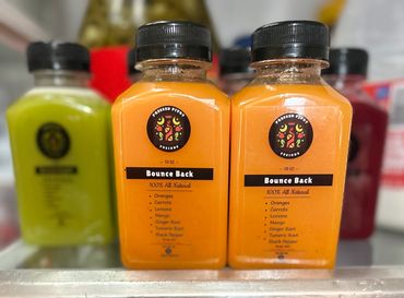 Two orange juice bottles labeled 'Bounce Back' in a fridge.