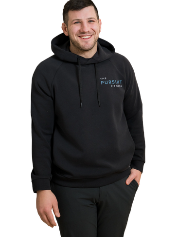 Smiling man in a black hoodie with The Pursuit Fitness logo.