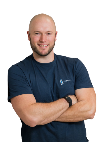 Smiling bald man with beard wearing a navy blue fitness t-shirt and a smartwatch.