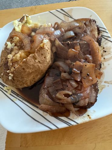 The sliced Rib Eye smothered in fried onions with a baked potato and gravy. Not a bad dinner.
