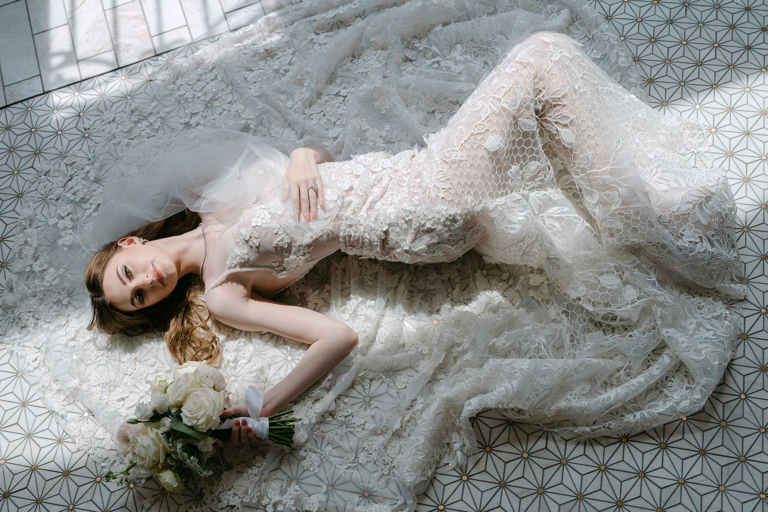 bride laying on the floor holding a flower bucket