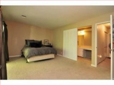 Primary bedroom freshly painted in a warm beige tone with plush carpet - interior painting project b