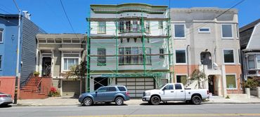 San Francisco Victorian building wrapped in protective scaffolding and netting before exterior repai