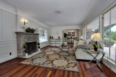Living room with freshly painted white walls, stone fireplace, and hardwood flooring - interior pain
