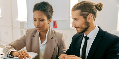 Two professionals discussing work in an office.
