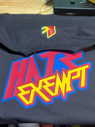 Black T-shirt with colorful graphic text and signature details.