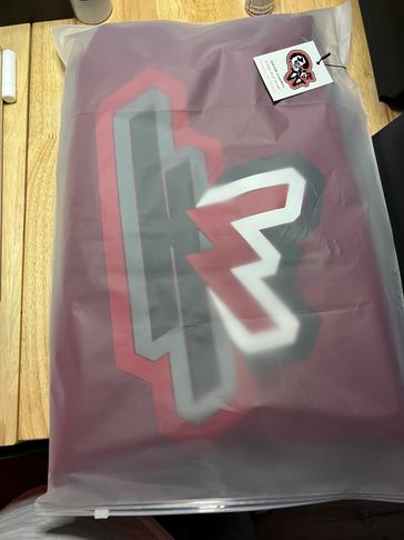 A packaged item with a bold geometric design in red, gray, and white.