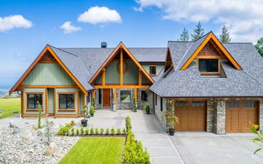 Modern rustic house with wooden accents and a well-maintained front yard.