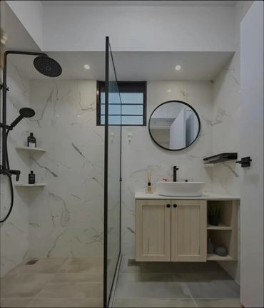 Modern bathroom with marble walls, black fixtures, and a floating wooden vanity.