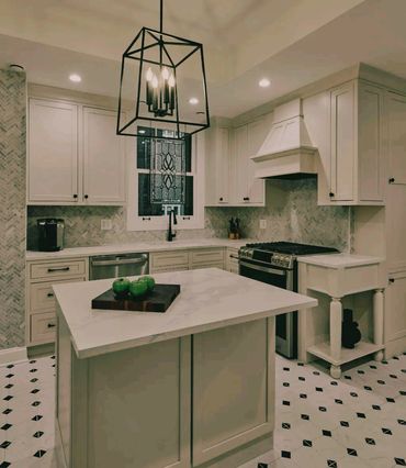 Modern kitchen with white cabinetry and a black geometric pendant light.