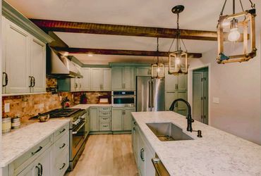 Rustic kitchen with wooden beams and modern appliances.