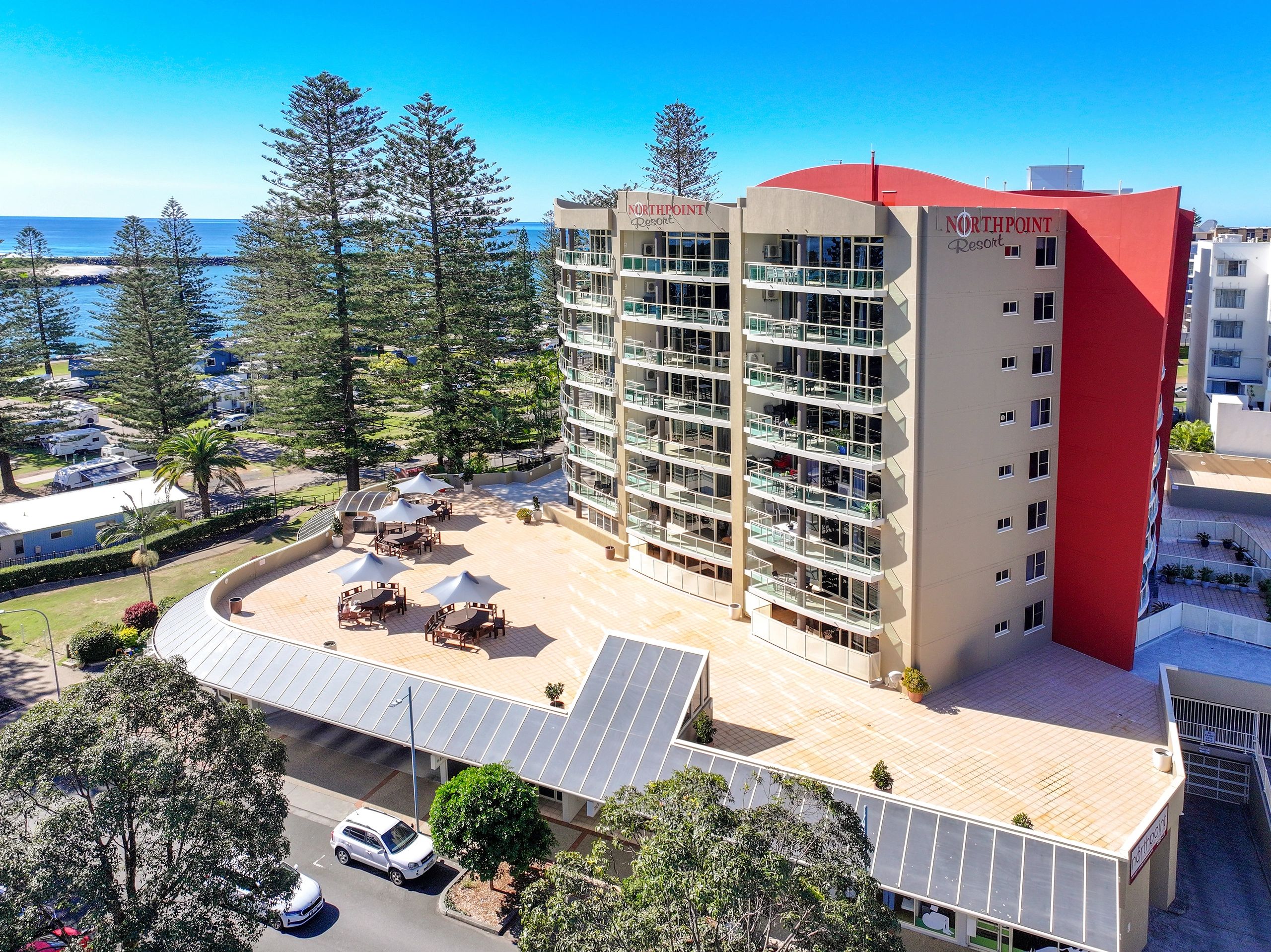 Northpoint Resort building by the beach with outdoor seating and ocean view.
