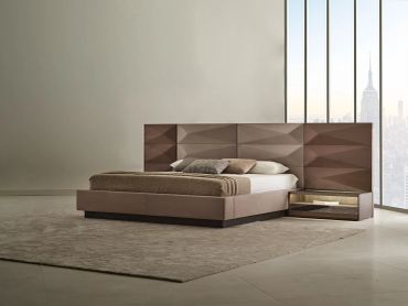 Modern bed with city view and textured headboard.