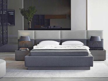 Modern bedroom with a gray bed and lamps.