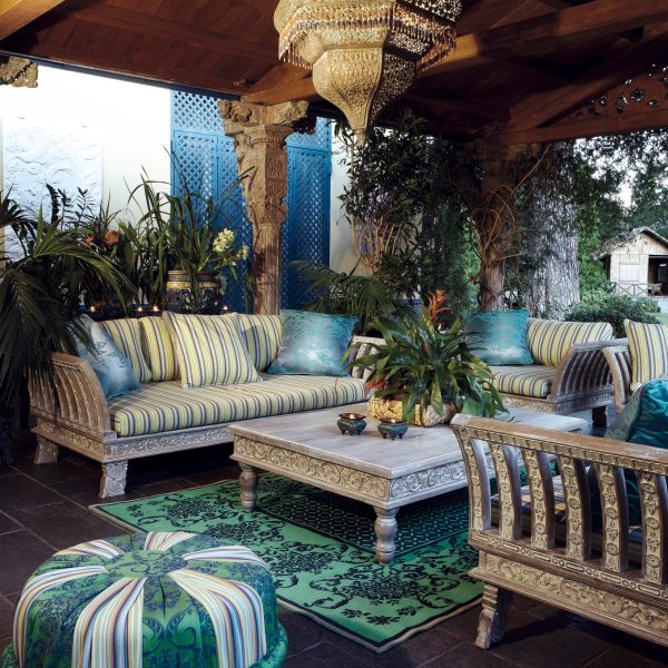 Elegant outdoor seating area with ornate furniture and greenery.
