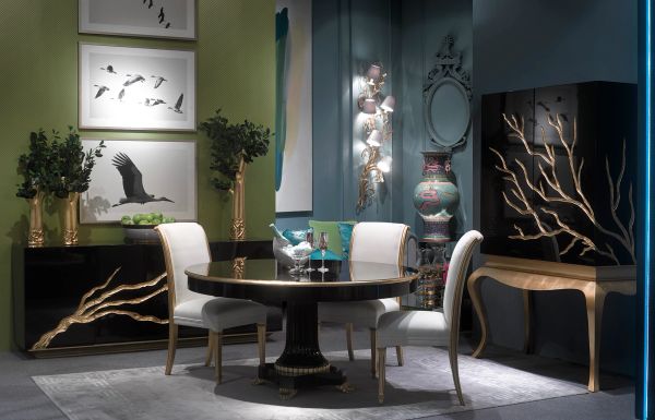 Elegant dining room with gold-accented furniture and bird-themed artwork.