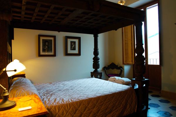 Antique four poster bed in a renovated bedroom with modern amenities in a vacation apartment Sulmona