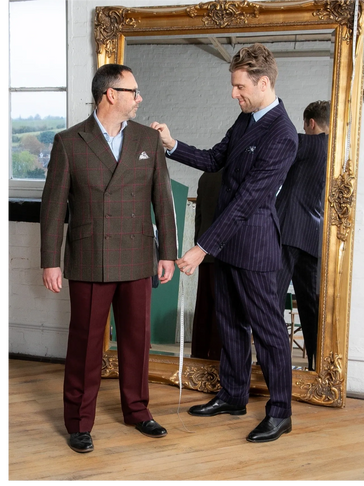 Nicholas measuring a customer in a double breasted jacket and contrast trouser