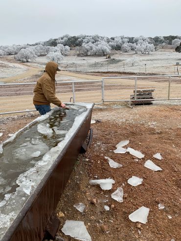 Ranchhand working on a frozen trough at Mountain House Ranch
