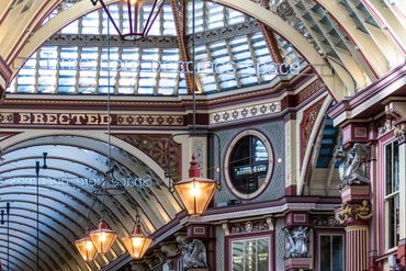 Ornate indoor shopping arcade with vintage lamps and detailed architecture.