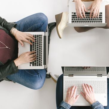 Three women typing on computers