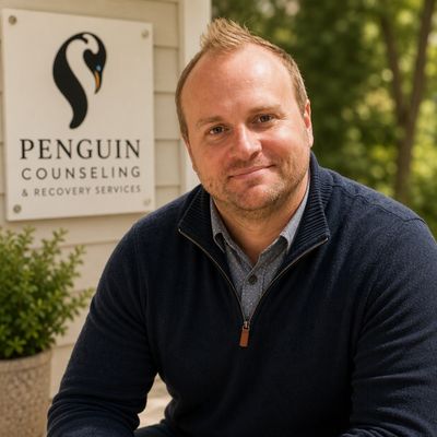 Paul Scarberry, LMHC, SUDP smiling in front of Penguin Counseling sign.
