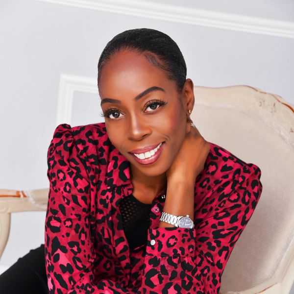 A smiling woman wearing a pink patterned coat