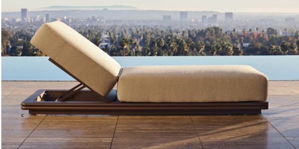 Modern outdoor lounge chair with adjustable backrest overlooking a cityscape.
