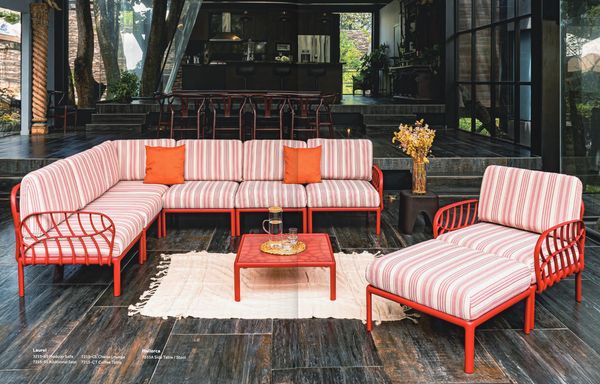 Modern outdoor seating with red frames and striped cushions on dark wooden floor.