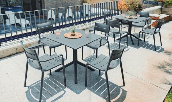 Outdoor patio with modern chairs and tables under sunlight.