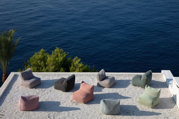 Colorful bean bags arranged on a terrace overlooking the ocean.