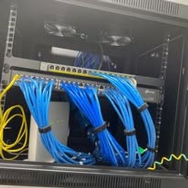 Network rack with organized blue Ethernet cables and switches.