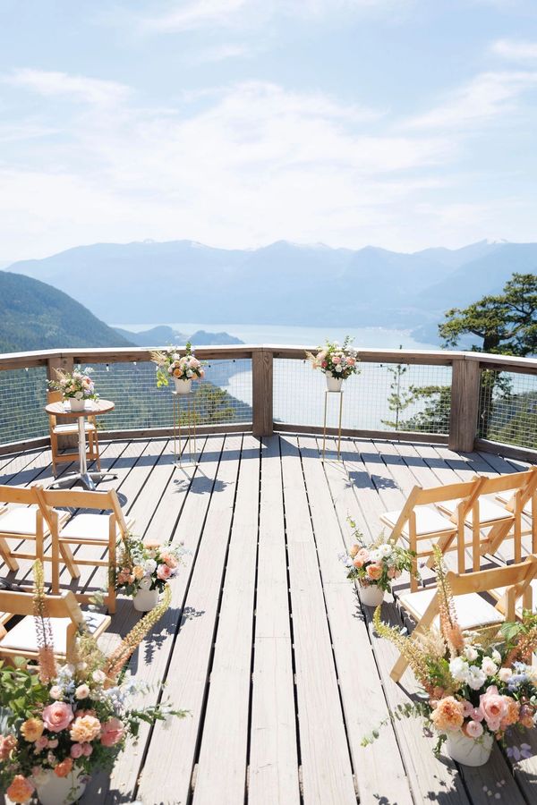 Outdoor wedding setup with floral arrangements and mountain view.