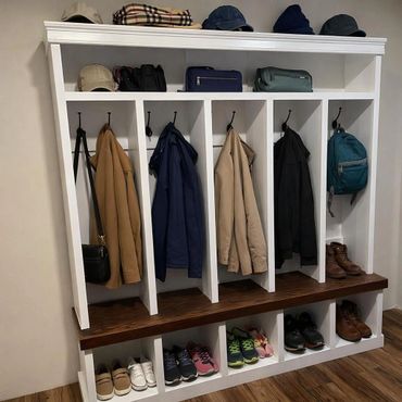Organized white wooden coat rack with jackets, bags, hats, and shoes neatly arranged.