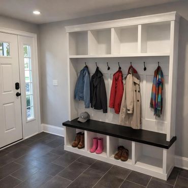 Modern entryway with organized coat hooks, bench, and shoe storage.